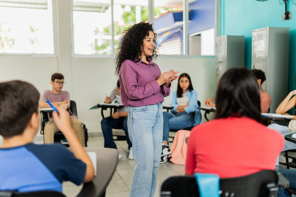 Mid adult teacher teaching students during class at classroom
